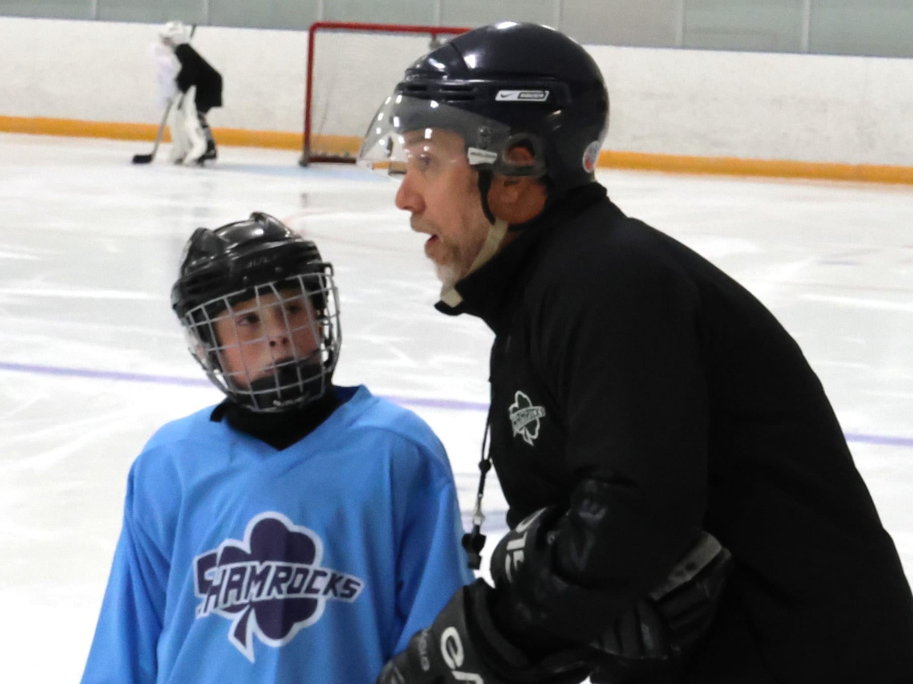 Jesse Candela talking one-on-one with a young player on the ice