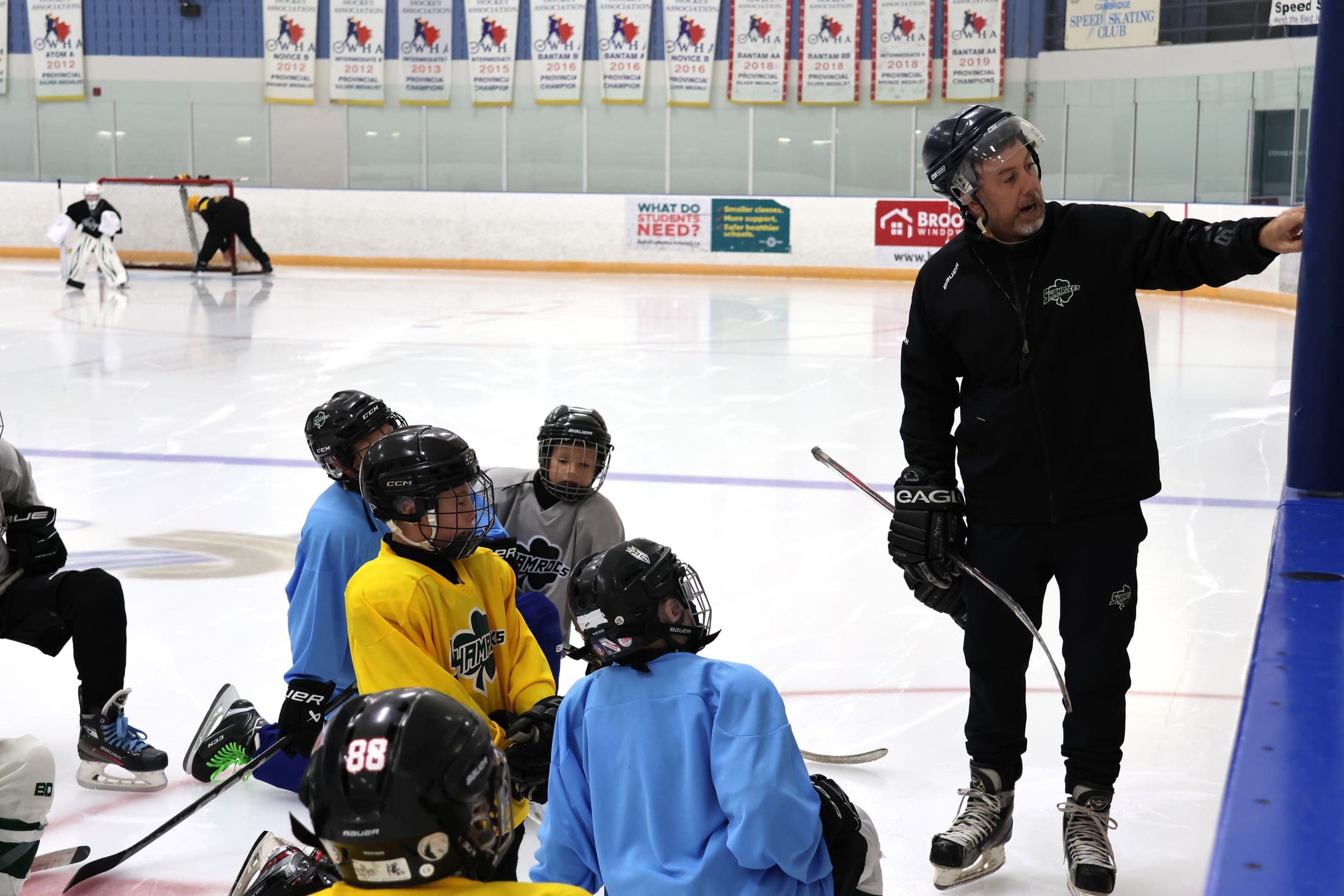 Jesse Candela coaching a group of young players on the ice